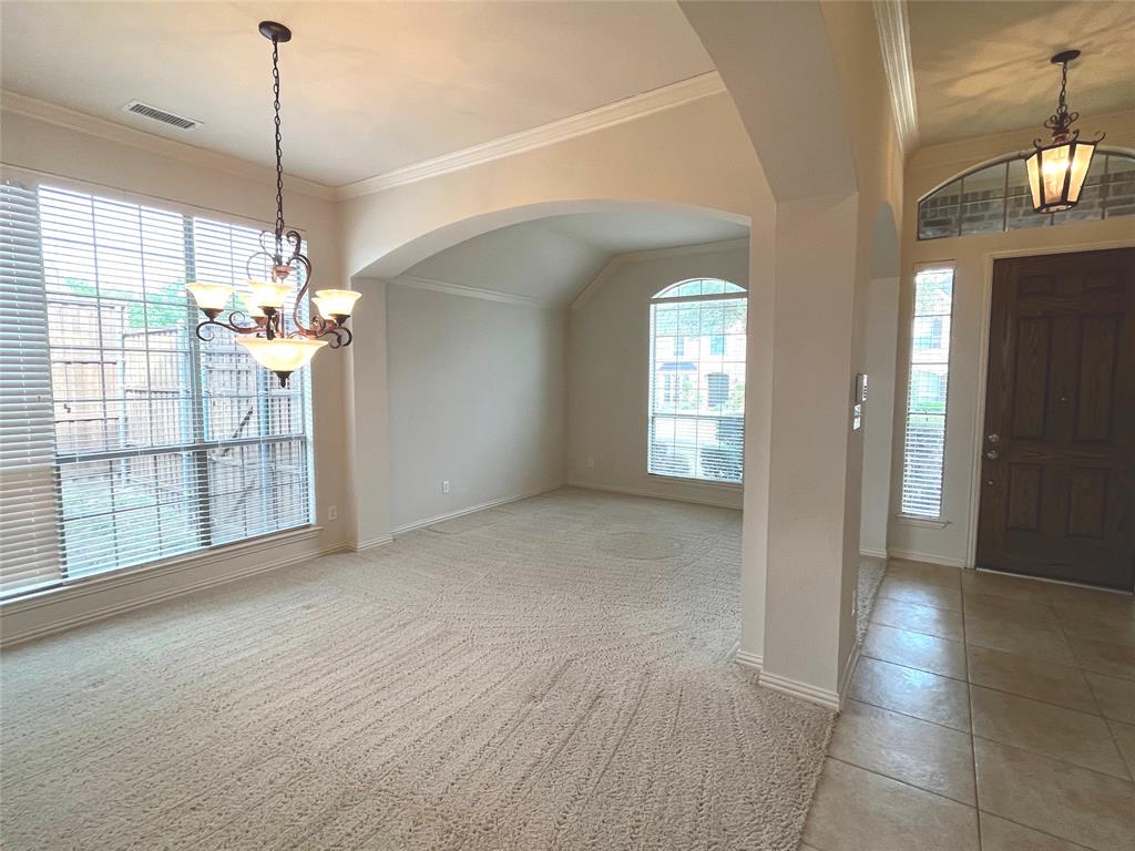 4101 White Porch Road Plano, TX 75024 - Photo 3 of 18 Entry foyer featuring a dark wood paneled door with an arched transom, sidelight windows, and a hanging lantern light fixture