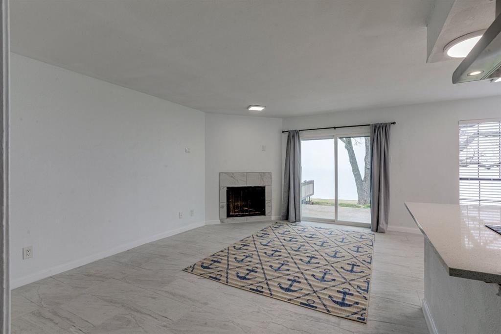 4606 Chaha Road, Unit 106 Garland, TX 75043 - Photo 17 of 22 Unfurnished living room with plenty of natural light and a high end fireplace