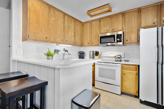 a kitchen with stainless steel appliances granite countertop a refrigerator a stove top oven a sink and dishwasher