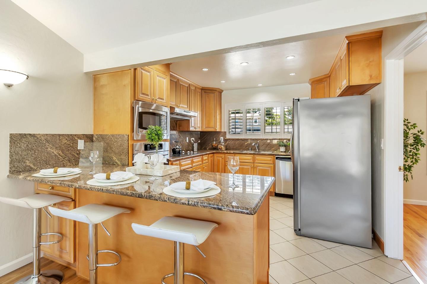 1051 Suffolk Way Los Altos, CA 94024 - Photo 14 of 47 a kitchen with a refrigerator and wooden cabinets