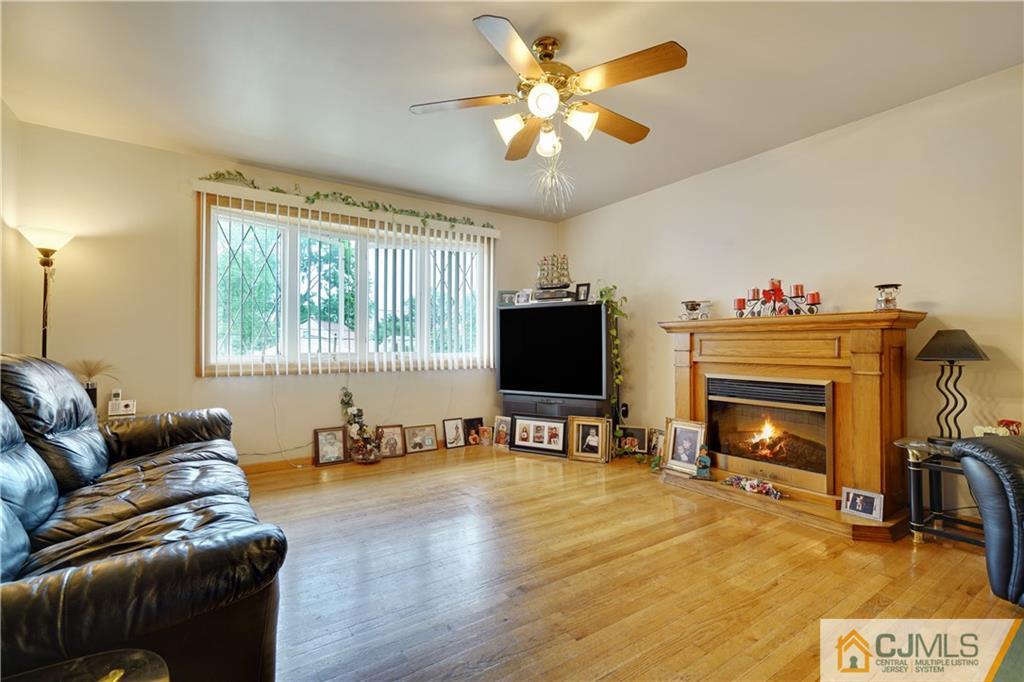 21 Louise Road Edison, NJ 08817 - Photo 4 of 29 a living room with furniture and a flat screen tv with wooden floor