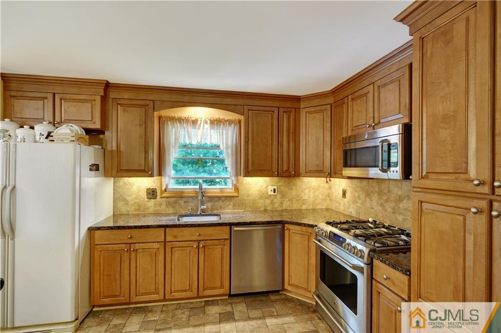 21 Louise Road Edison, NJ 08817 - Photo 8 of 29 a kitchen with granite countertop cabinets stainless steel appliances and a window