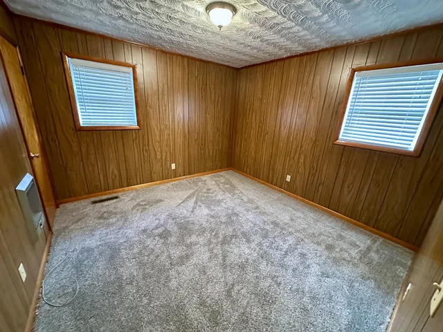 a view of an empty room with window and stairs