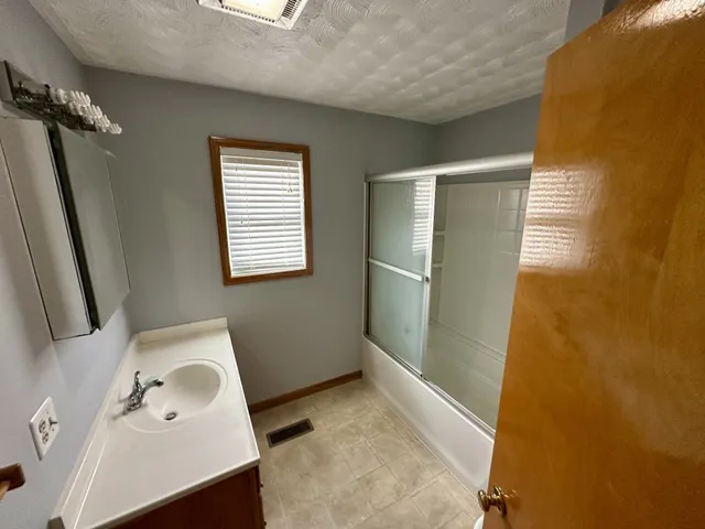 a bathroom with a sink a mirror and shower