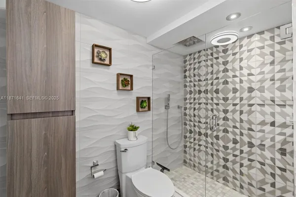 a bathroom with a granite countertop toilet a sink a mirror and shower curtain