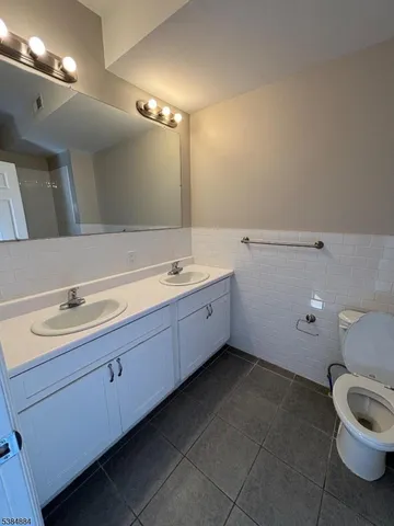 a bathroom with a double vanity sink and a toilet