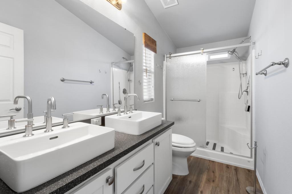 1545 East El Rodeo Road, Unit 42 Fort Mohave, AZ 86426 - Photo 33 of 45 a bathroom with a double vanity sink toilet mirror and shower