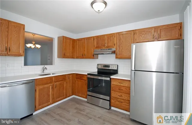 a kitchen with stainless steel appliances a refrigerator and a sink