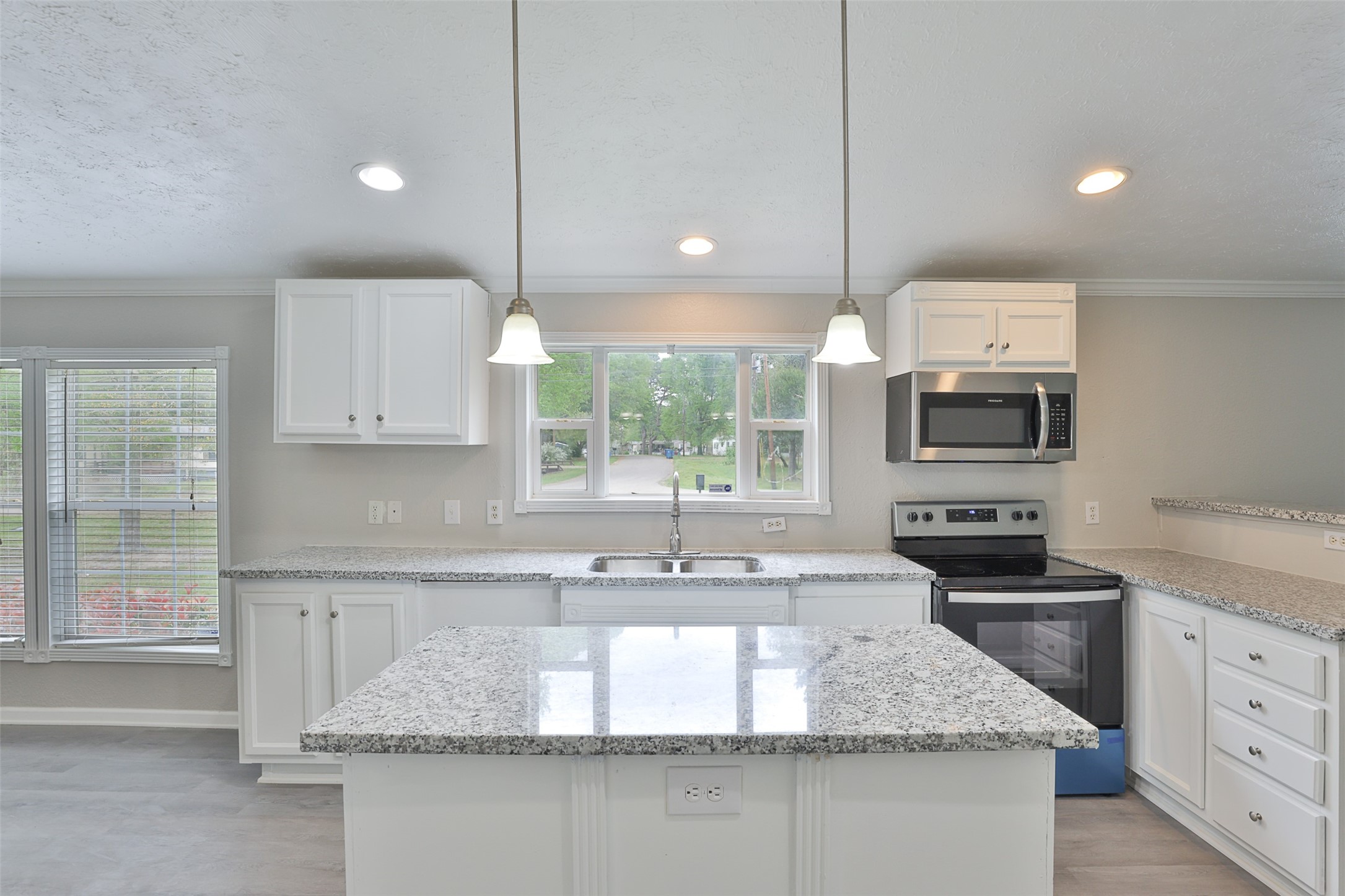 1520 West Creek Drive Conroe, TX 77304 - Photo 11 of 29 a kitchen with kitchen island granite countertop a sink a counter top space appliances and cabinets