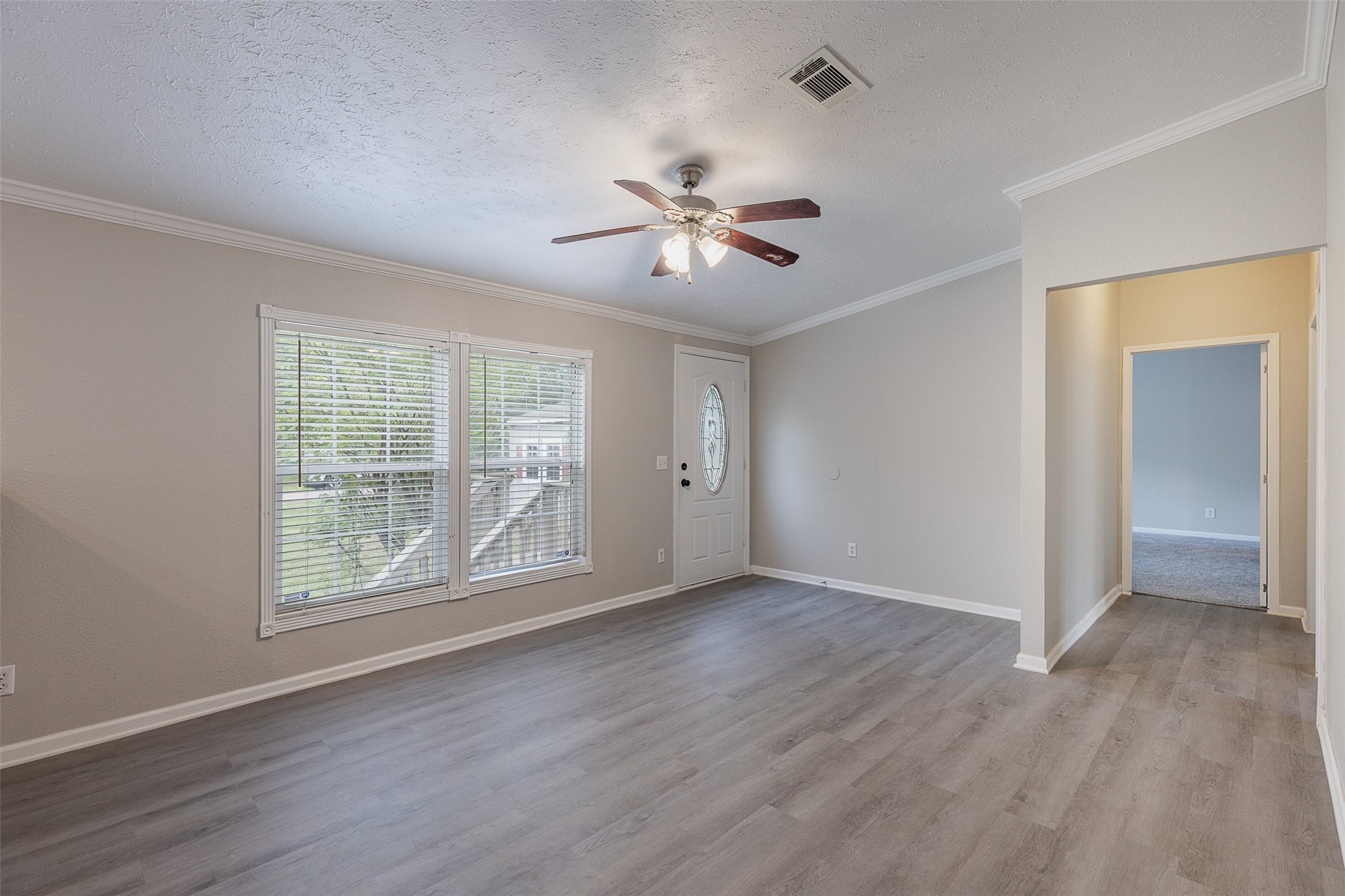 1520 West Creek Drive Conroe, TX 77304 - Photo 3 of 29 a view of an empty room with a window and wooden floor