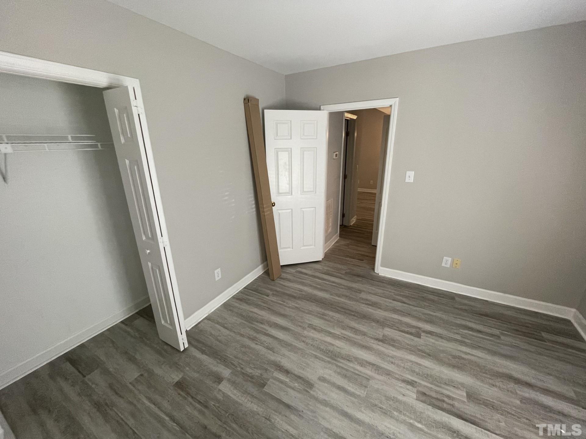 243 New Bern Place, Unit 301 Raleigh, NC 27601 - Photo 11 of 19 an empty room with wooden floor and closet