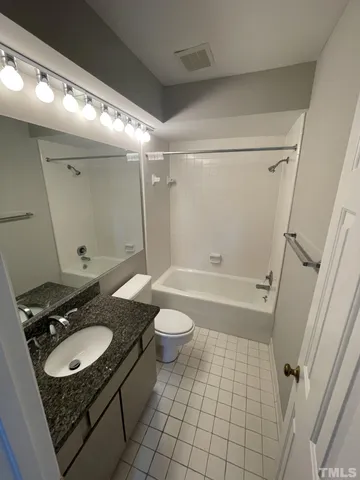 a bathroom with a granite countertop sink toilet a mirror and shower