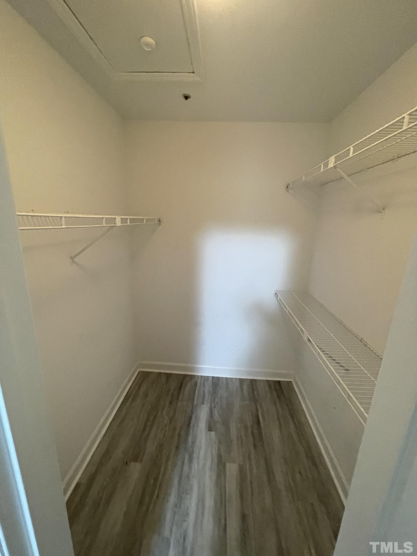 243 New Bern Place, Unit 301 Raleigh, NC 27601 - Photo 16 of 19 a view of a room with wooden floor and white walls