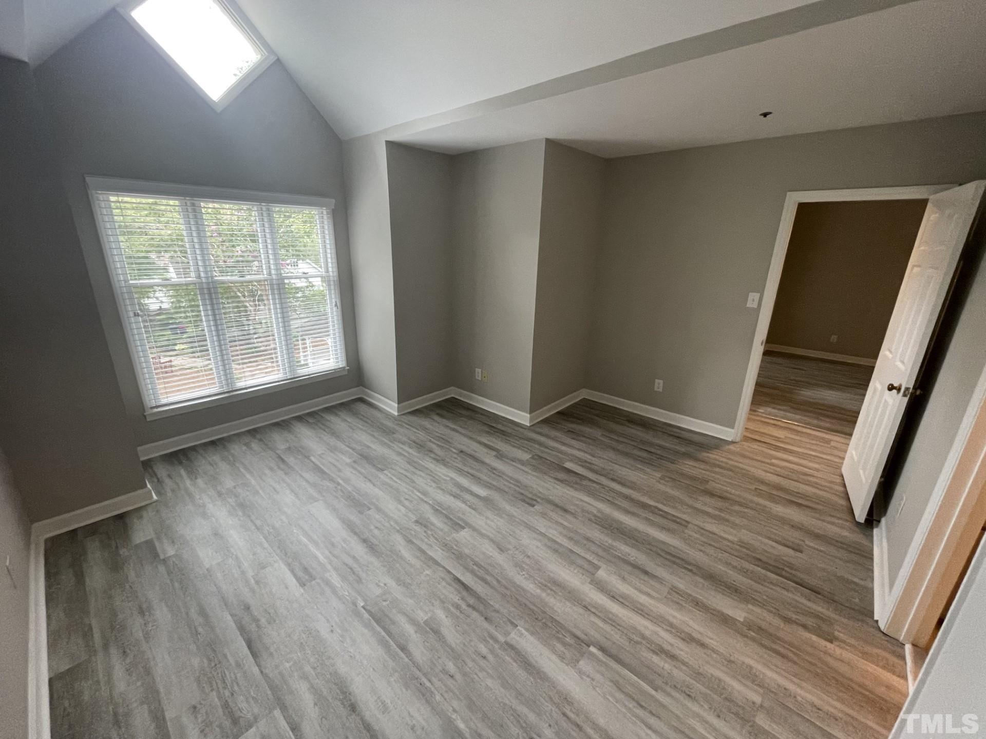 243 New Bern Place, Unit 301 Raleigh, NC 27601 - Photo 17 of 19 an empty room with wooden floor and windows