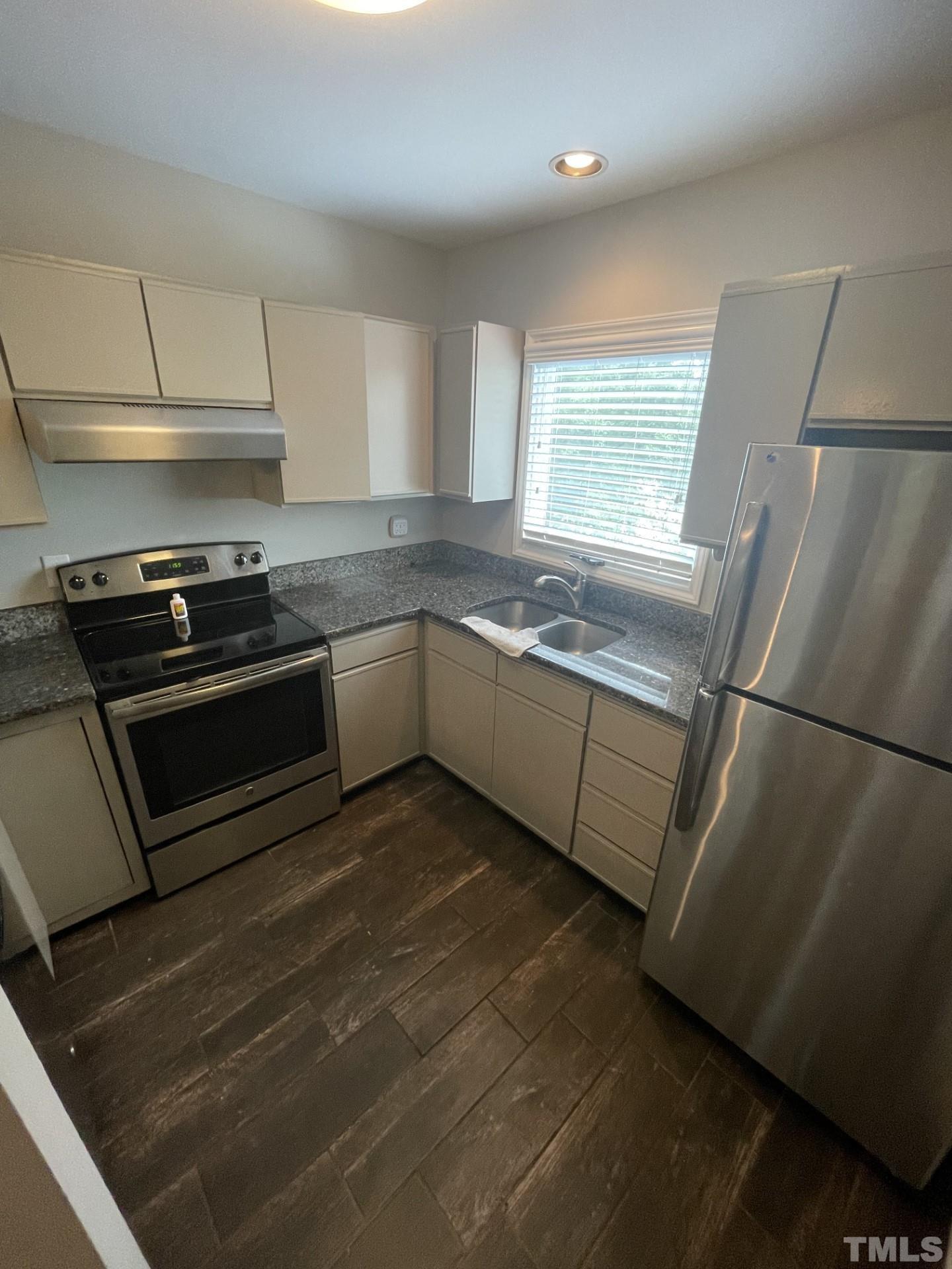 243 New Bern Place, Unit 301 Raleigh, NC 27601 - Photo 7 of 19 a kitchen with stainless steel appliances granite countertop a stove a sink and a refrigerator