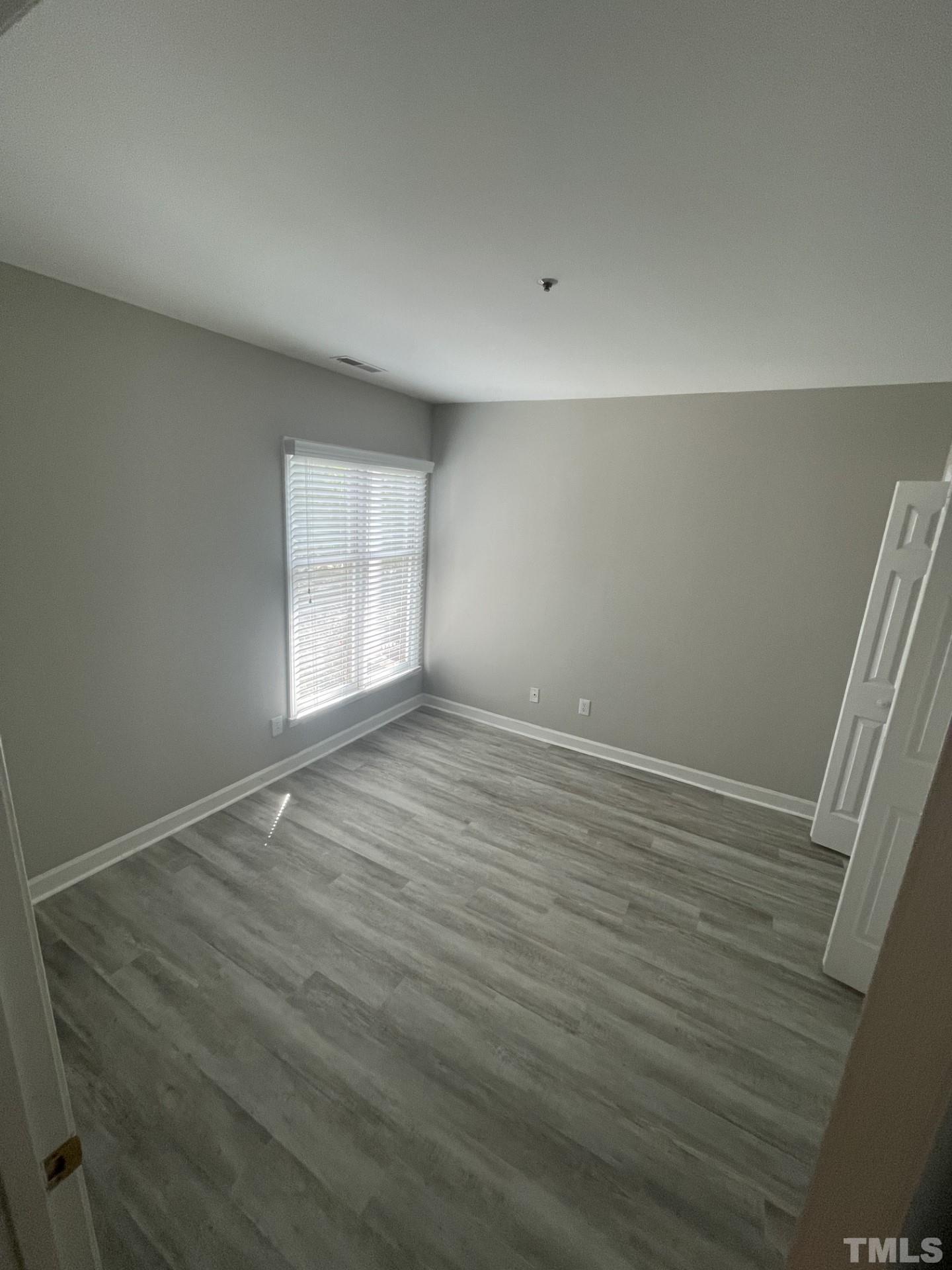 243 New Bern Place, Unit 301 Raleigh, NC 27601 - Photo 10 of 19 an empty room with wooden floor and windows