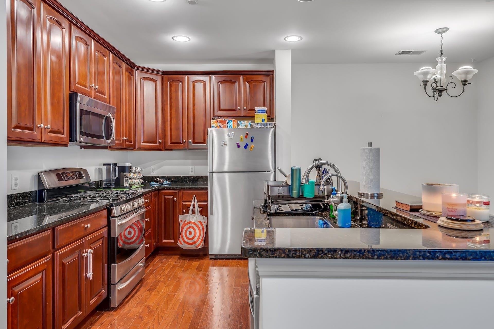 7400 River Road, Unit 315 North Bergen, NJ 07047 - Photo 6 of 19 a kitchen with stainless steel appliances granite countertop a refrigerator a sink dishwasher a stove and a dining table with wooden floor