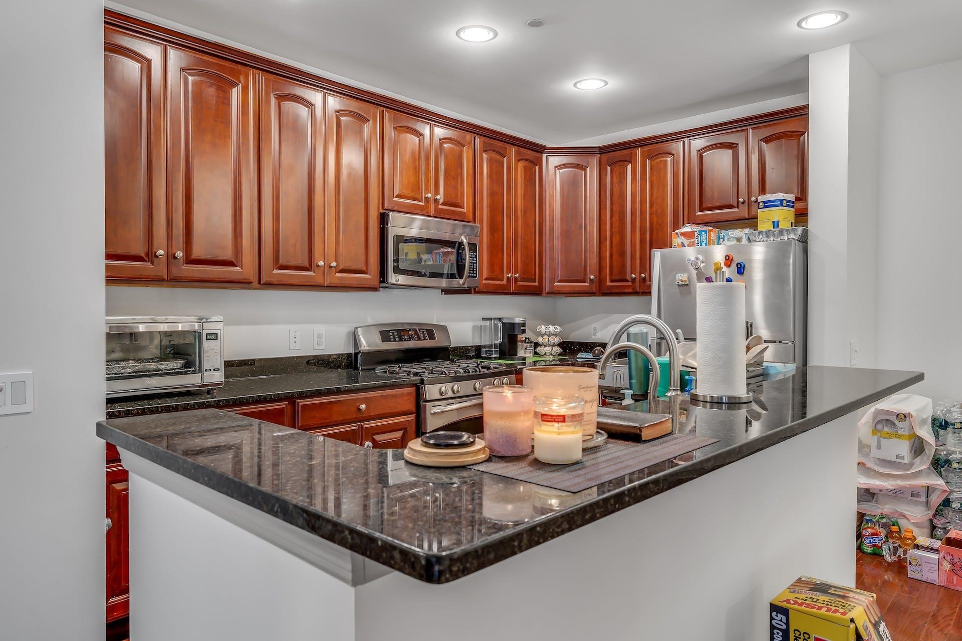7400 River Road, Unit 315 North Bergen, NJ 07047 - Photo 7 of 19 a kitchen with stainless steel appliances granite countertop a sink a stove and a microwave