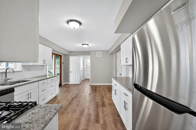 a large kitchen with a lot of counter space and wooden floor