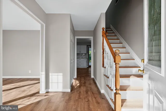 a view of a hallway with wooden floor and staircase