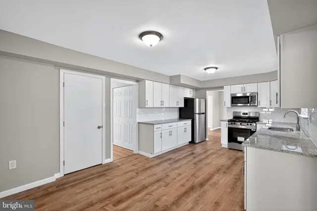 a kitchen with a refrigerator stove top oven and sink