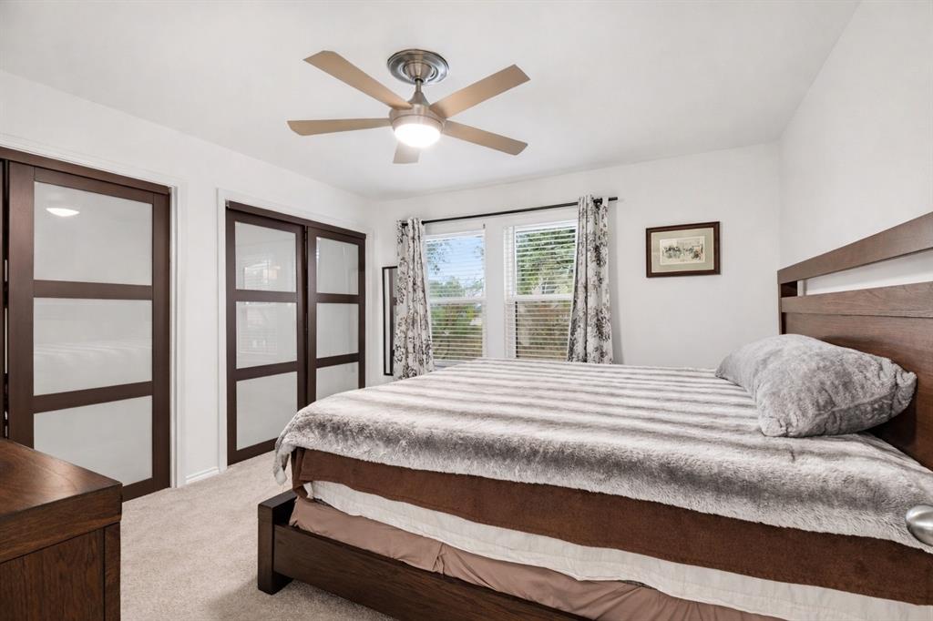 5616 Preston Oaks Road, Unit 102 Dallas, TX 75254 - Photo 8 of 11 a bedroom with a large bed and a chandelier