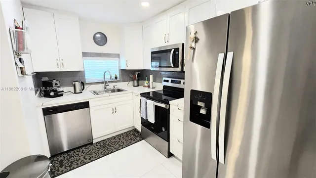 a kitchen with stainless steel appliances a stove a sink a refrigerator and cabinets