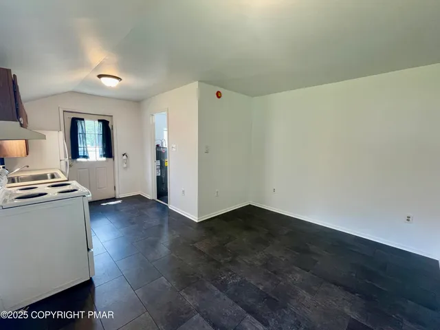 a view of a kitchen with flat screen tv and refrigerator