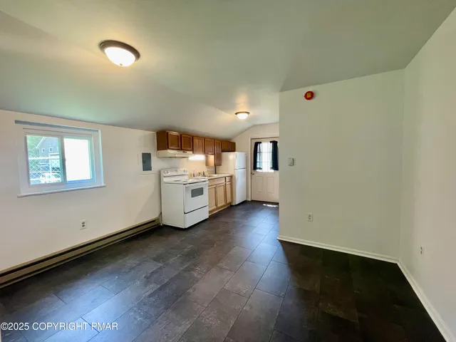 a view of a kitchen with a sink a stove top oven