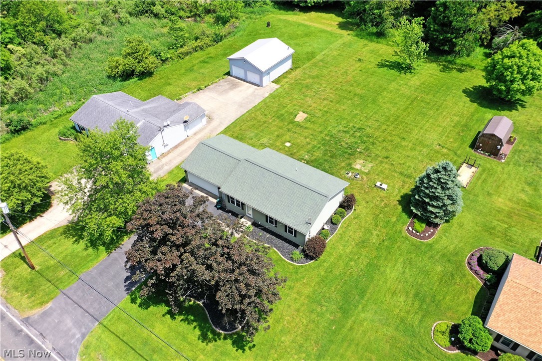 754 Warner Road Hubbard, OH 44425 - Photo 6 of 46 Spacious property featuring a main residence with a green roof, a detached two-car garage, an additional outbuilding, and expansive green lawns with mature trees