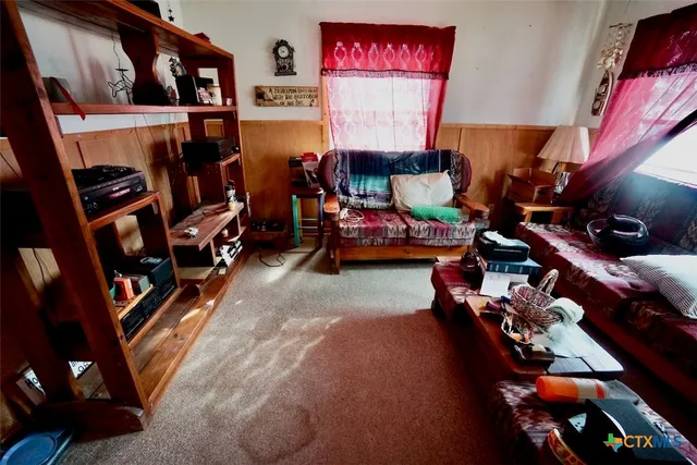 a living room with furniture and a book shelf
