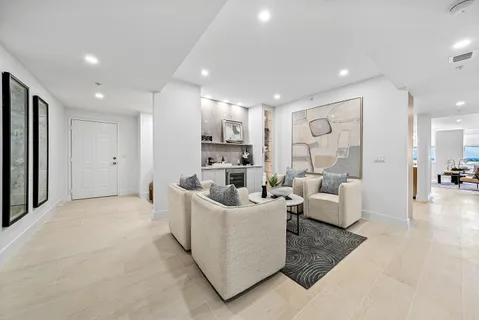 a kitchen with stainless steel appliances granite countertop a sink a stove a refrigerator and white cabinets with wooden floor