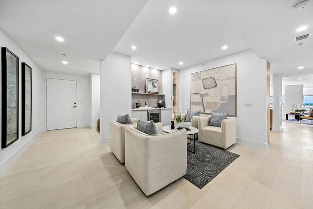 a kitchen with stainless steel appliances granite countertop a sink a stove a refrigerator and white cabinets with wooden floor