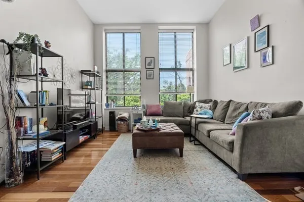 a living room with furniture a flat screen tv and a large window