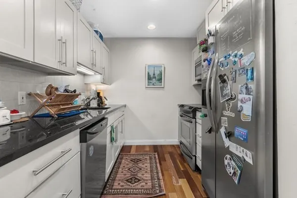 a kitchen with stainless steel appliances granite countertop a refrigerator and a stove