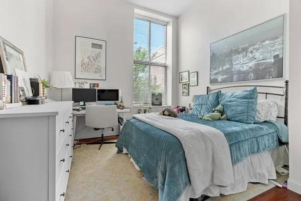 a bedroom with a bed and wooden floor