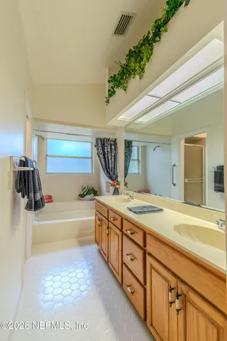 a bathroom with a tub sink and mirror