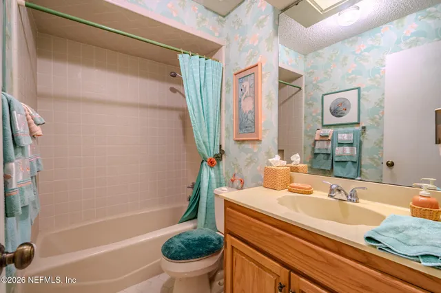 a bathroom with a granite countertop sink a toilet and shower