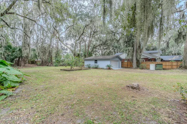 a view of a house with backyard and tree
