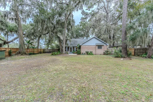 a front view of a house with a yard and trees