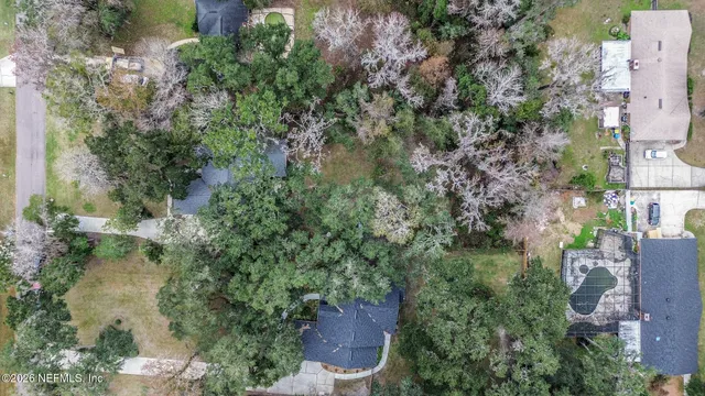 an aerial view of residential house with outdoor space and trees all around