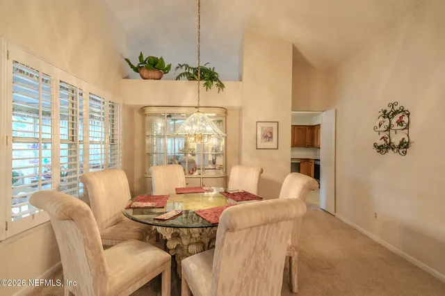 a dining room with furniture a chandelier and window