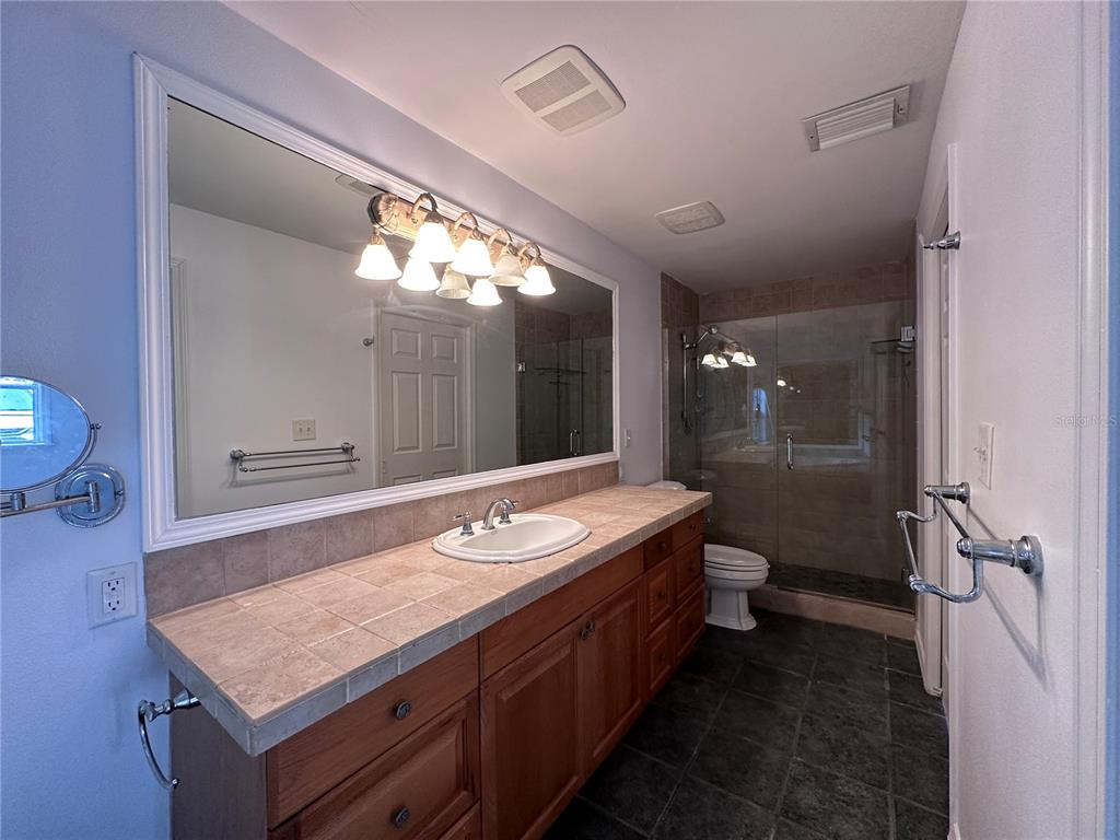 315 Sunburst Court Clearwater, FL 33755 - Photo 15 of 23 a bathroom with a granite countertop sink a toilet a mirror and vanity