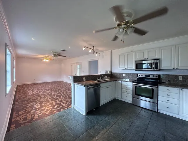 a kitchen with stainless steel appliances kitchen island granite countertop a stove and a sink