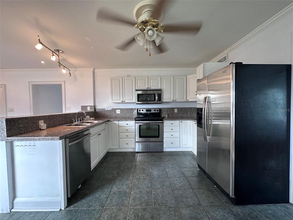 315 Sunburst Court Clearwater, FL 33755 - Photo 5 of 23 a kitchen with stainless steel appliances granite countertop a refrigerator a stove a sink and a microwave
