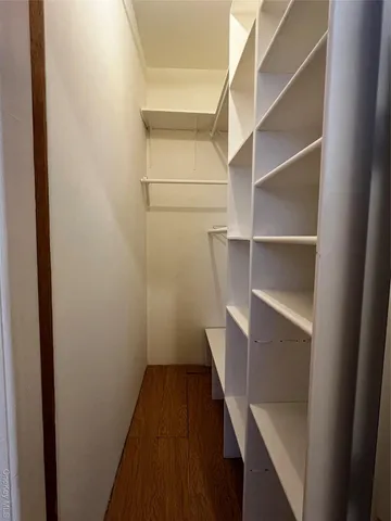 a view of walk in closet with empty racks