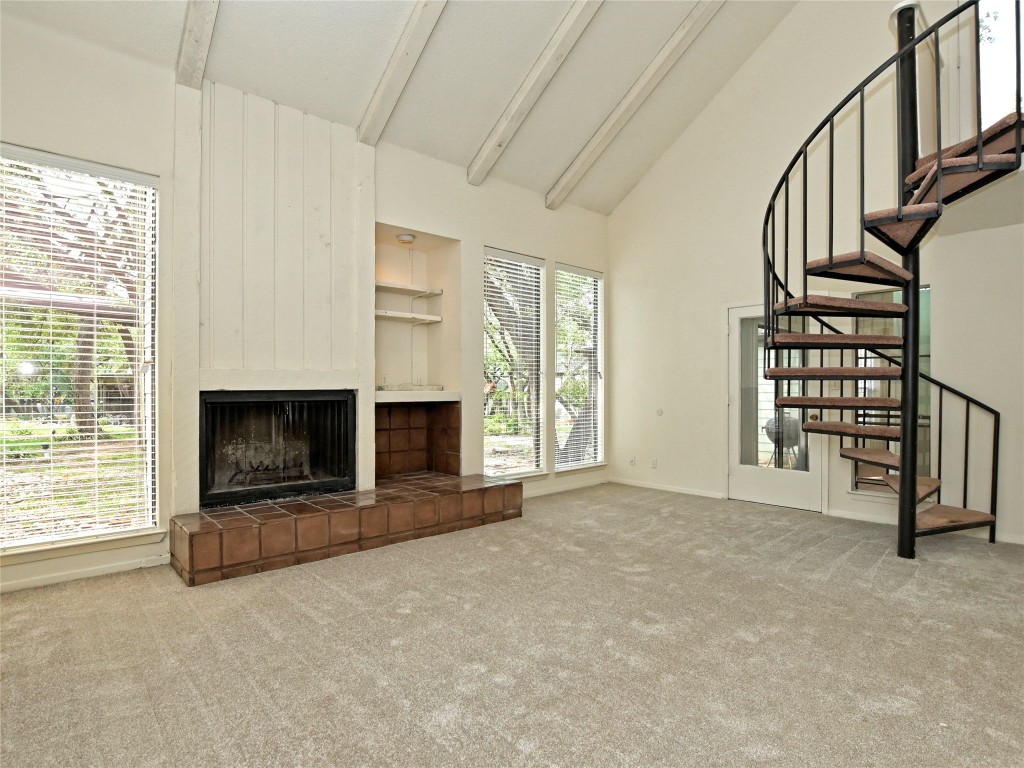 3 Casa Verde Street Lakeway, TX 78734 - Photo 2 of 30 an empty room with windows a fireplace and a flat tv screen