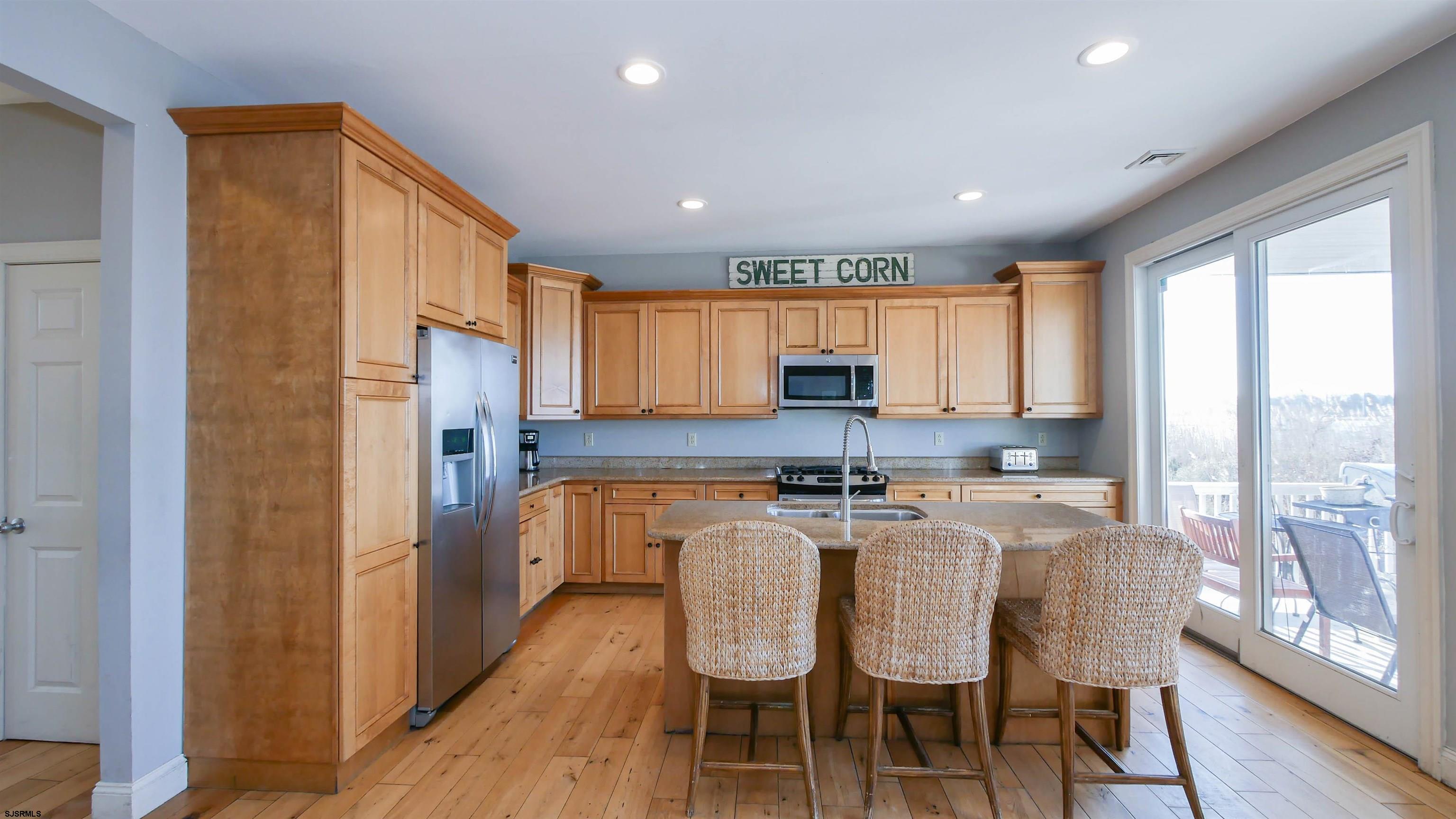 2070 West Riverside Drive Atlantic City, NJ 08401 - Photo 14 of 40 a kitchen with stainless steel appliances granite countertop a stove a refrigerator a kitchen island with a dining table and chairs