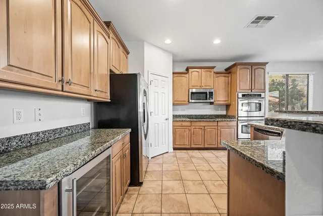 a kitchen with stainless steel appliances granite countertop a stove a sink and a refrigerator