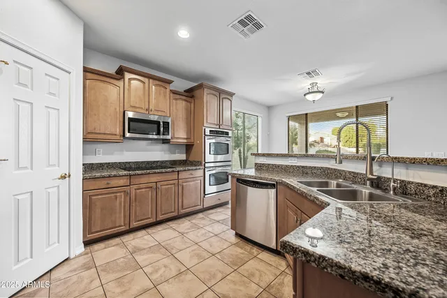 a kitchen with stainless steel appliances granite countertop a sink stove and microwave